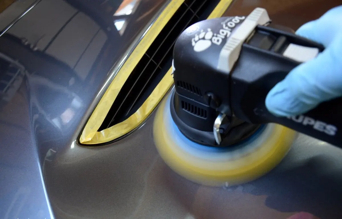 Polisher working next to masked trim on an M4 GTS